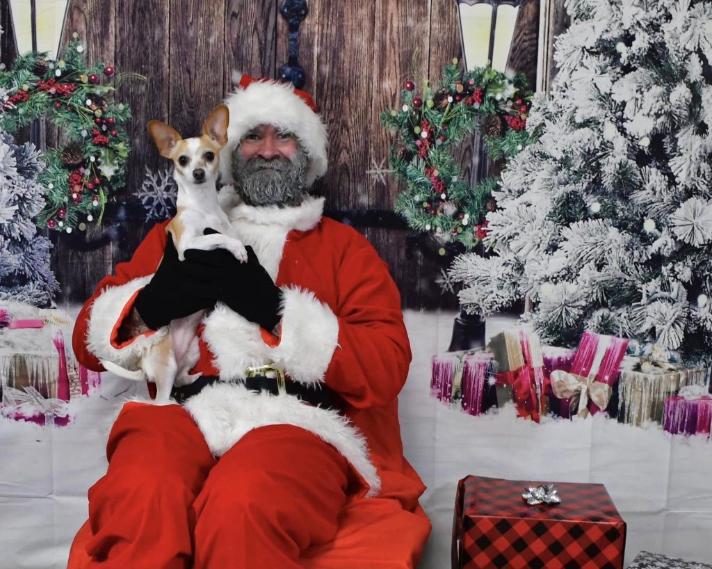 A dog posing for a photo with Santa Pawsh